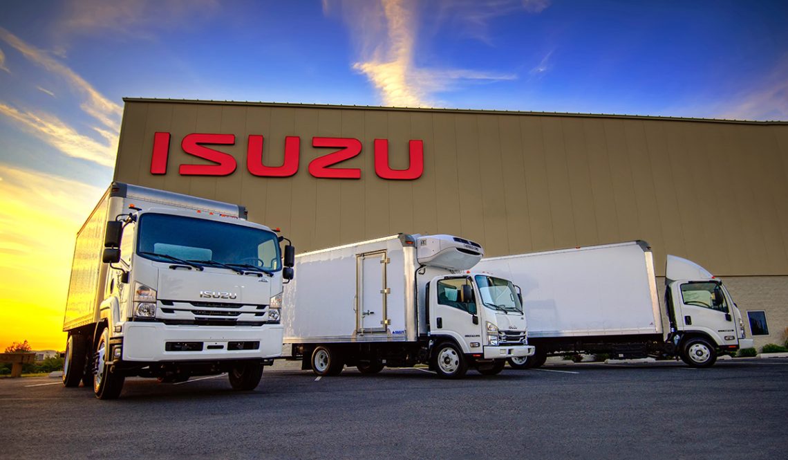 Three Isuzu trucks parked in front of dealership